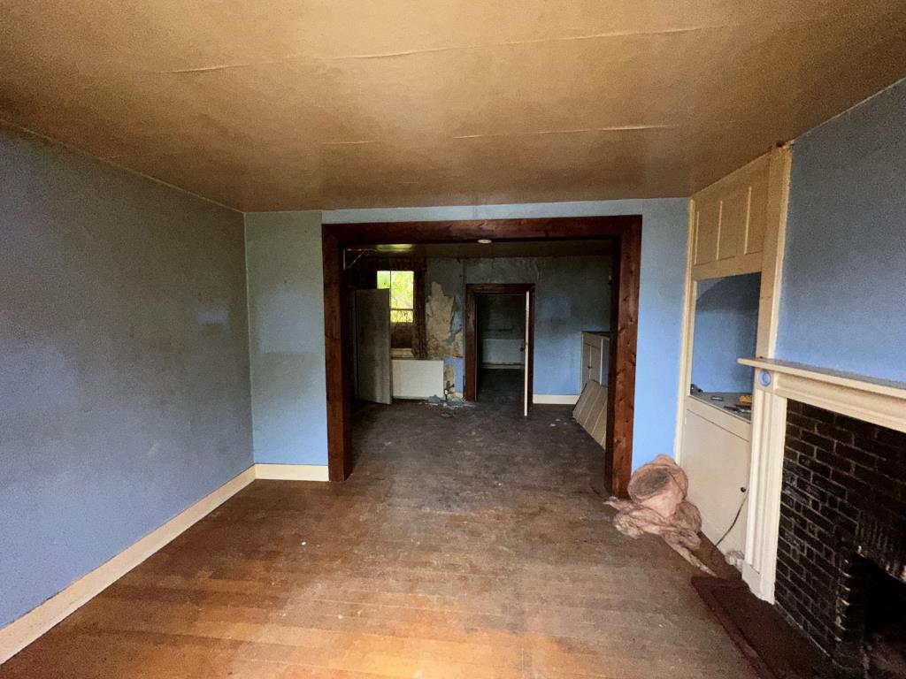 Lot: 103 - THREE-BEDROOM SEMI-DETACHED HOUSE FOR REPAIR - Living Room with fireplace